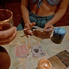 two women sitting at a table with cards and candles in front of them on twitter