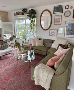 a living room filled with furniture and a large mirror on the wall above it's windows