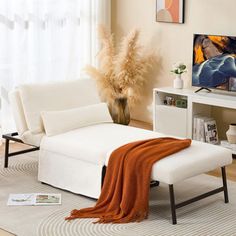 a living room with a white couch, chair and large painting on the wall behind it