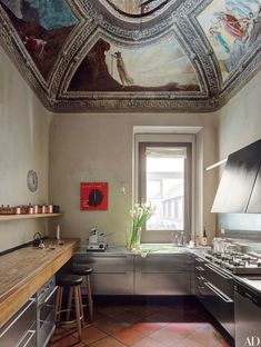 a kitchen with a painting on the ceiling