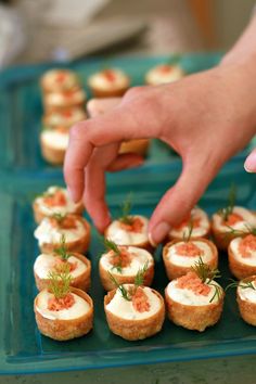 a person reaching for small appetizers on a tray