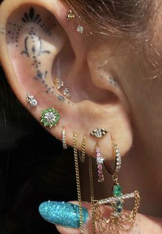 a person with some piercings on their ear and behind the ear is a piece of jewelry