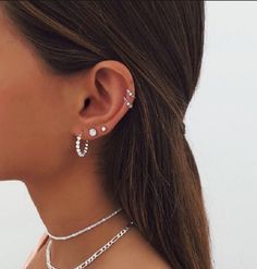 a close up of a person wearing some kind of necklace and earring with pearls on it