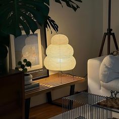 a lamp sitting on top of a wooden table next to a white couch in a living room