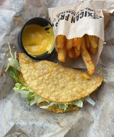 a taco sandwich and french fries on a wrapper