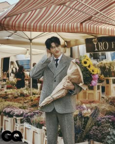 a man in a suit and tie is talking on his cell phone while holding a bag