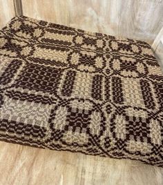 a brown and white rug sitting on top of a wooden floor next to a wall