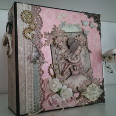 an altered photo frame with flowers and laces on the edges, sitting on top of a table