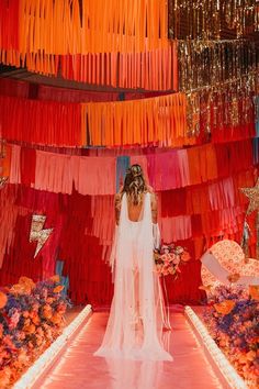 the bride is walking down the aisle with her veil draped over her head and flowers on the floor