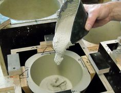 a person is pouring cement into a bowl