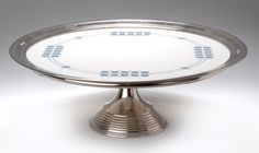 a silver plate on a white surface with numbers and arrows painted on it, as well as the base