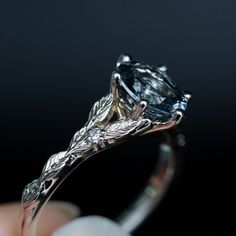 a close up of a person's hand holding an engagement ring