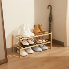 several pairs of shoes are lined up on a rack in front of a mirror and door