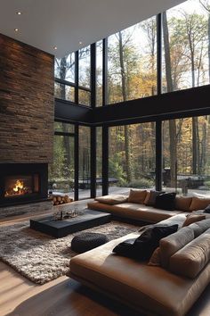 a living room with large windows and a couch in front of the fire place,