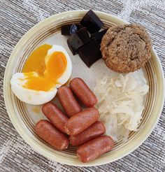 a plate with eggs, sausages and cookies on it