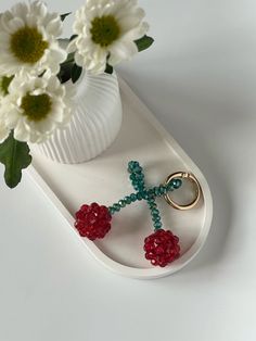 a white tray with flowers and a cross keychain sitting on top of it