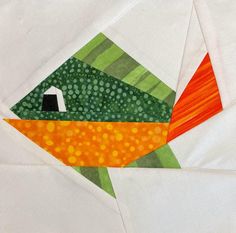 an orange and green fish quilted on top of white fabric