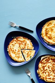 three blue plates with food on them next to silverware