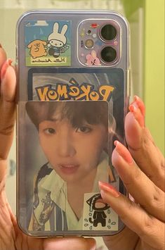 a woman holding up a cell phone case with an image of a pokemon on it