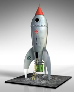 a metal model of a rocket with a red star on it's top and ladder to the bottom