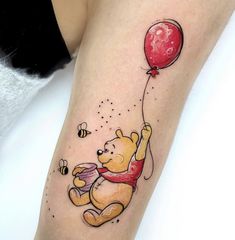 a winnie the pooh tattoo with a red balloon and honeybees on it