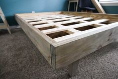 a bed frame made out of wooden slats in a room with carpeted flooring