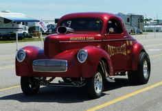 an old red truck driving down the road