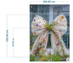 a large bow with flowers on it is shown in front of a building and measurements