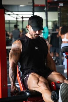 a man sitting on top of a bench in a gym