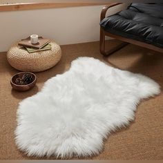 a white sheepskin rug on the floor next to a chair