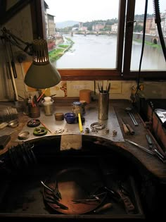 an old workbench with tools and other items on the table in front of a large window