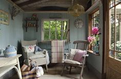 a room filled with furniture and flowers in vases on top of windows sill