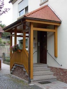 a small building with steps leading up to the front door and entry way on brick paversed walkway