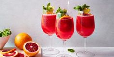 three wine glasses filled with blood oranges and garnish