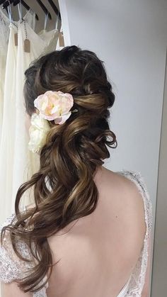 the back of a woman's head with long hair and flowers in her hair