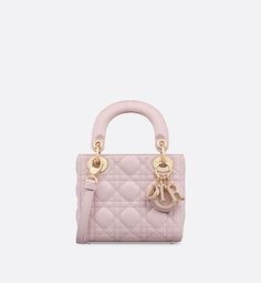 The Lady Dior bag epitomizes the House's vision of elegance and beauty. Sleek and refined, the timeless style is crafted in pale pink lambskin with Cannage stitching, creating the unmistakable quilted texture. Pale pink enamel D.I.O.R. charms complement the new removable chain strap with alternating pale gold-finish metal and pastel enamel O-links. The miniature Lady Dior bag can be carried by hand or worn crossbody as an ideal evening companion.. Lady Dior Mini, Mini Lady Dior, Dior Star, Icon Shoes, Bags Pink, Dior Book Tote, Antique Pink, Wallet Pouch, Candy Pink