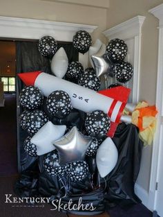 black and white balloons are arranged in the shape of a rocket on display at a party