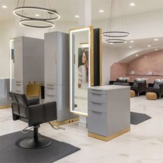 a hair salon with chairs, mirrors and lights