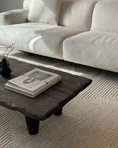 a coffee table with a book on it in the middle of a living room area