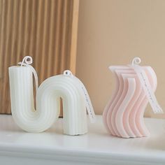 three white and pink letters sitting on top of a mantle next to a window sill