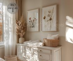 a white dresser sitting in front of a window next to a basket filled with flowers