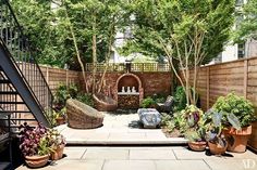 an outdoor patio with lots of plants and trees