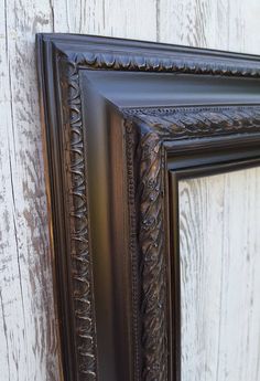 an ornate frame on the side of a wooden wall