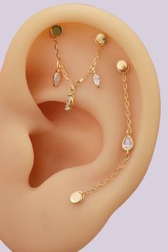 an ear with three different types of piercings on it's side, including a chain