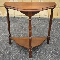 a small wooden table with two shelves on it's sides and one shelf below