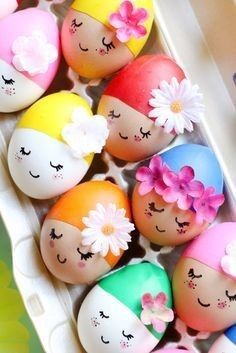 an egg carton filled with painted eggs and flowers on top of each one in different colors