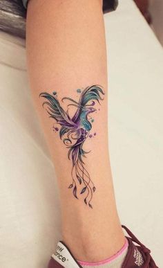 a woman's foot with a tattoo on it and a bird in the middle