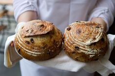 two freshly baked breads being held in their hands