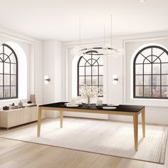 an empty room with two large windows and a table