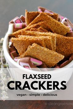 a white bowl filled with crackers on top of a wooden table next to lavender flowers